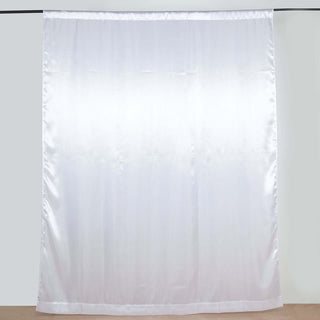 White satin curtain panel hanging against a plain background