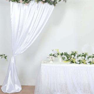 Wedding decor with white drapery and floral arrangements.