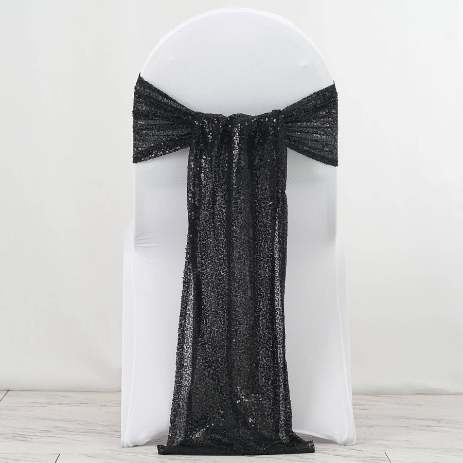 Black sequin chair sash draped over a white chair.