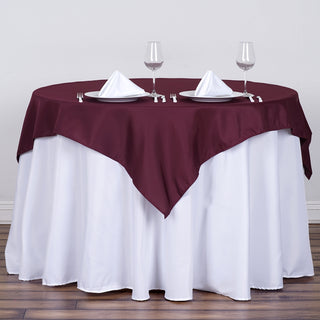 Add Elegance to Your Event with the Burgundy Square Seamless Polyester Table Overlay