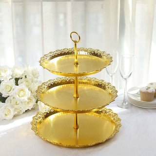 Three-tier gold serving tray on a table with flowers and glassware.