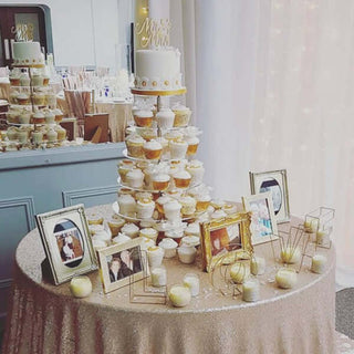 Elegant wedding cupcake tower with framed photos and decorative candles.