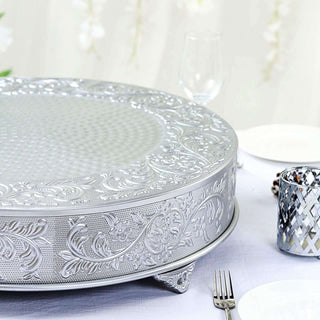 Decorative silver serving tray with intricate floral design on a dining table.