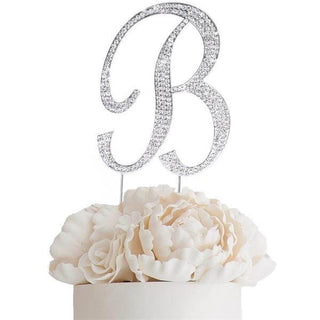 Elegant silver glitter "B" cake topper with white floral accents.