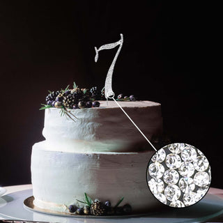 Silver number 7 cake topper with crystal embellishments on a decorated cake.
