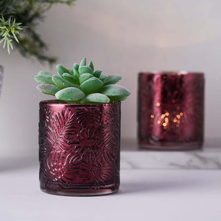 Decorative burgundy glass candle holder with succulent plant