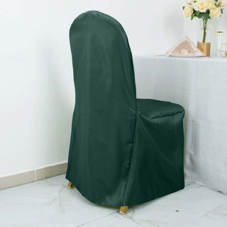 Green chair cover draped over a dining chair in a minimalist setting.