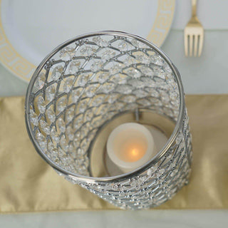 Elegant crystal candle holder with silver detailing and soft glowing candle inside.