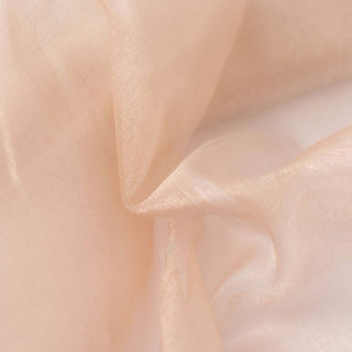 Peach-colored sheer fabric showing soft texture and drape.