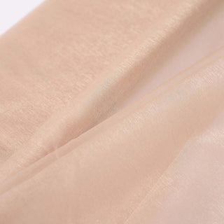 Close-up of soft, shimmering nude fabric texture.
