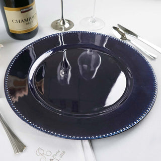 Navy blue decorative charger plate with beaded rim on a table setting.