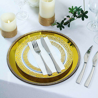 Elegant gold and white dinnerware set with utensils on a table.