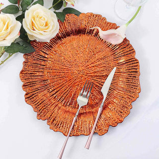 Shiny orange decorative plate with utensils and floral accents