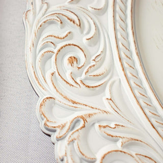 Ornate white picture frame with detailed carving and distressed finish.