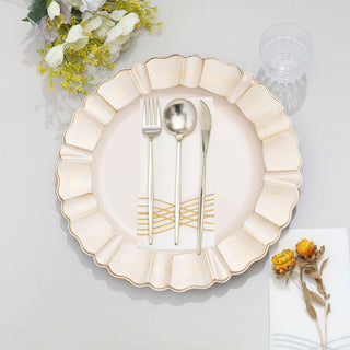 Elegant round plate with gold rim, fork, knife, and napkin on a table setting.
