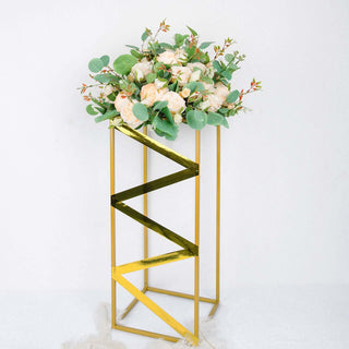 Gold geometric plant stand with floral arrangement on top