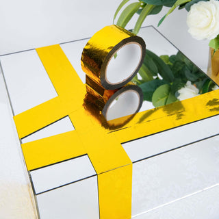 Mirrored gift box with shiny gold tape decoration.