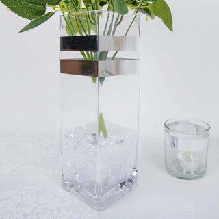 Clear glass vase with silver accents and decorative stones.