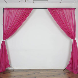 Pink sheer curtains draped on a black stand against a white wall.