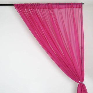 Sheer pink curtain draped elegantly on a black rod.