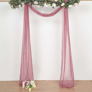 Burgundy sheer drapery with floral accents for event decoration