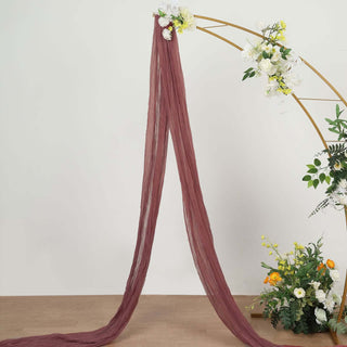 Burgundy sheer fabric draped elegantly with floral arrangement