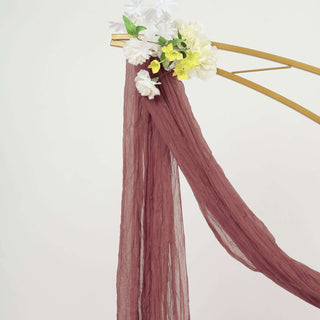 Burgundy drapery with floral accents on a golden arch