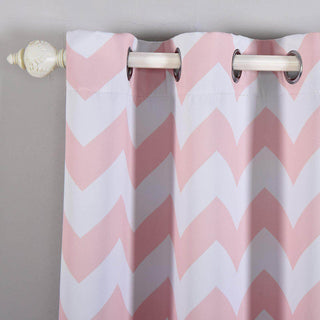 Pink chevron patterned curtain with silver grommets hanging on a white rod.