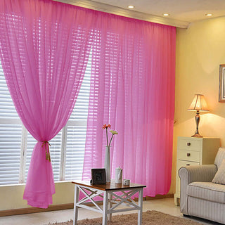 Sheer pink curtains in a cozy living room setting.