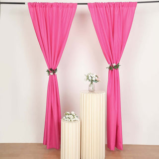 Pink curtains with floral accents on cream pedestals in a staged setting.