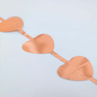 Rose gold heart garland decoration on a white background