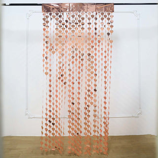 Rose gold heart-shaped garland curtain on a plain backdrop.