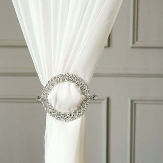Elegant curtain tieback with crystal accents on white fabric.