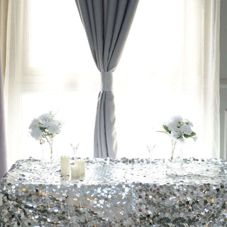 Elegant table setting with silver sequined tablecloth and floral arrangements.