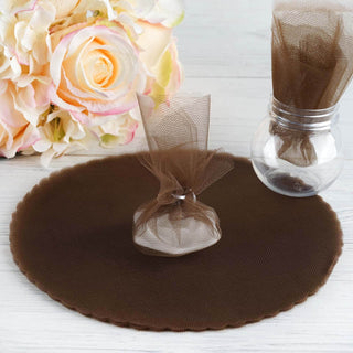 Brown tulle favor bags and round mat on a white wooden surface.