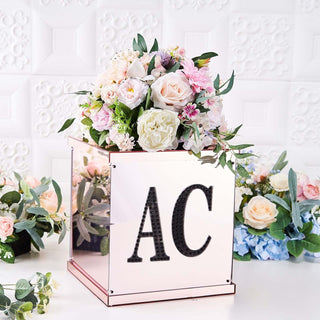 Floral arrangement in mirrored box with initials "AC" on a white backdrop