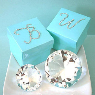 Turquoise gift boxes with decorative pearls and crystal diamonds on a plate.