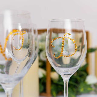 Personalized crystal wine glasses with orange rhinestone initials.