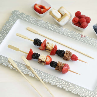 Fruit and dessert skewers on a decorative platter.