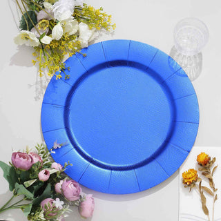 Blue disposable plate surrounded by flowers on a white surface.