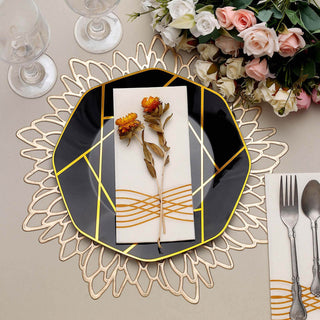 Elegant black plate with gold accents, floral napkin, and decorative table setting.