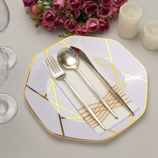 Elegant octagonal plate with gold accents, silverware, and floral arrangement.