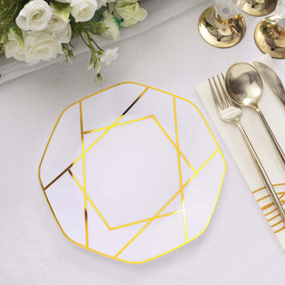 Geometric gold-trimmed white plate on a table setting with cutlery.