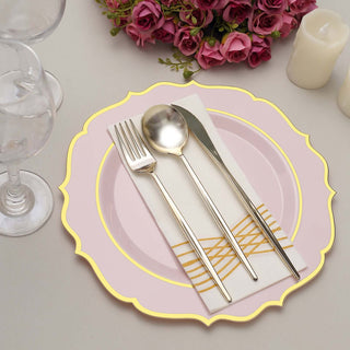 Elegant pink plate with gold accents, silver cutlery, and a napkin.
