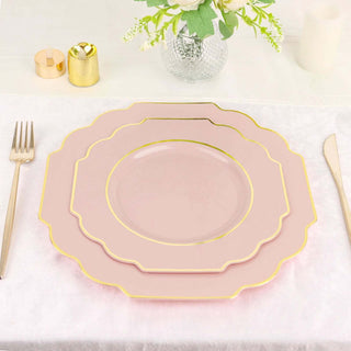 Pink scalloped plates with gold trim set on a white tablecloth.