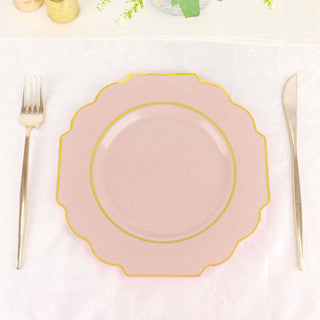 Pink scalloped plate with gold trim on a white tablecloth