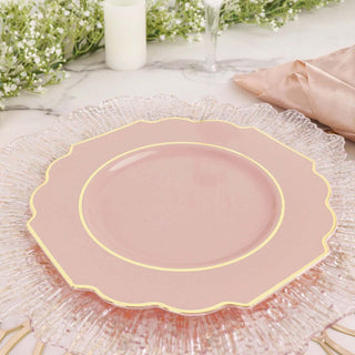 Elegant pink plate with scalloped edges and gold trim on a decorative glass charger.