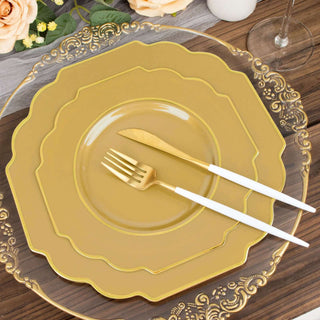 Elegant gold dinner plate set with white utensils on a wooden table.