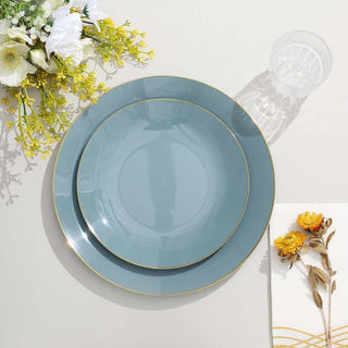 Elegant blue plates with gold rim, styled with flowers and a glass.
