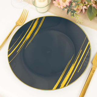 Navy plate with gold brushstroke design on a table setting.